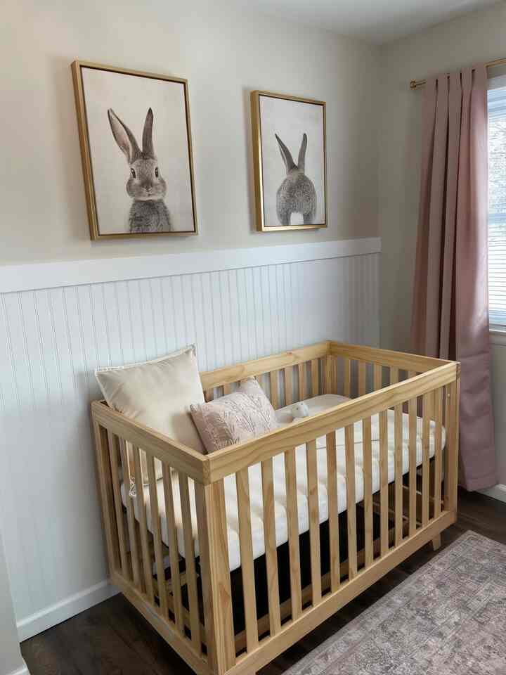 Natural color and pastel toned kids' room featuring a wooden crib and whimsical bunny posters creating a cozy atmosphere