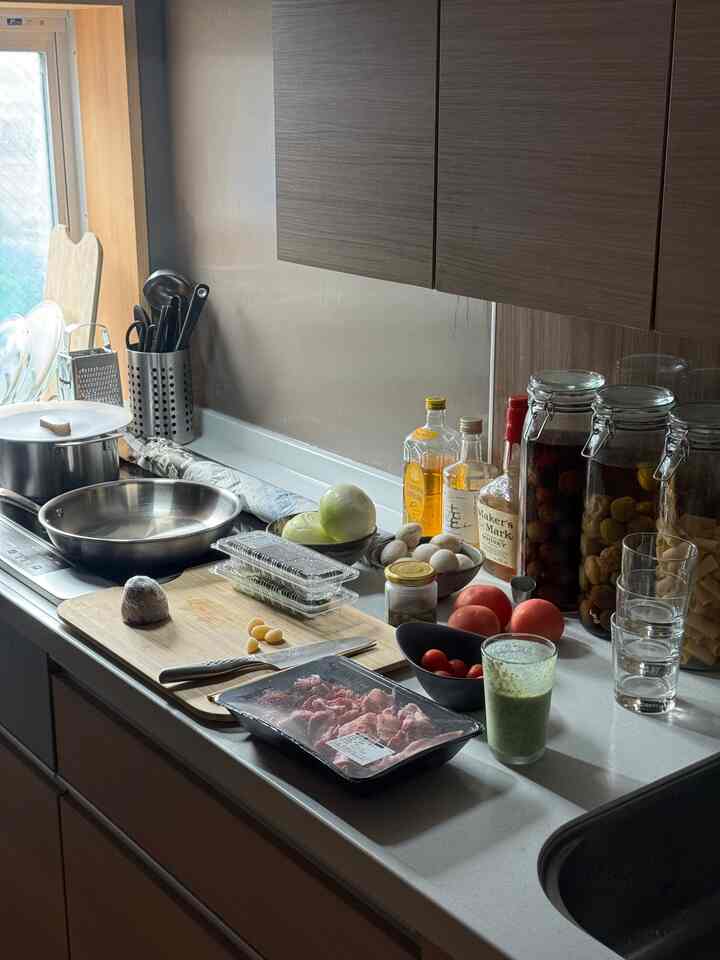 ナチュラルカラーのブラウンとホワイトが調和するキッチン、調理器具と食材が配置された雰囲気のあるインテリア