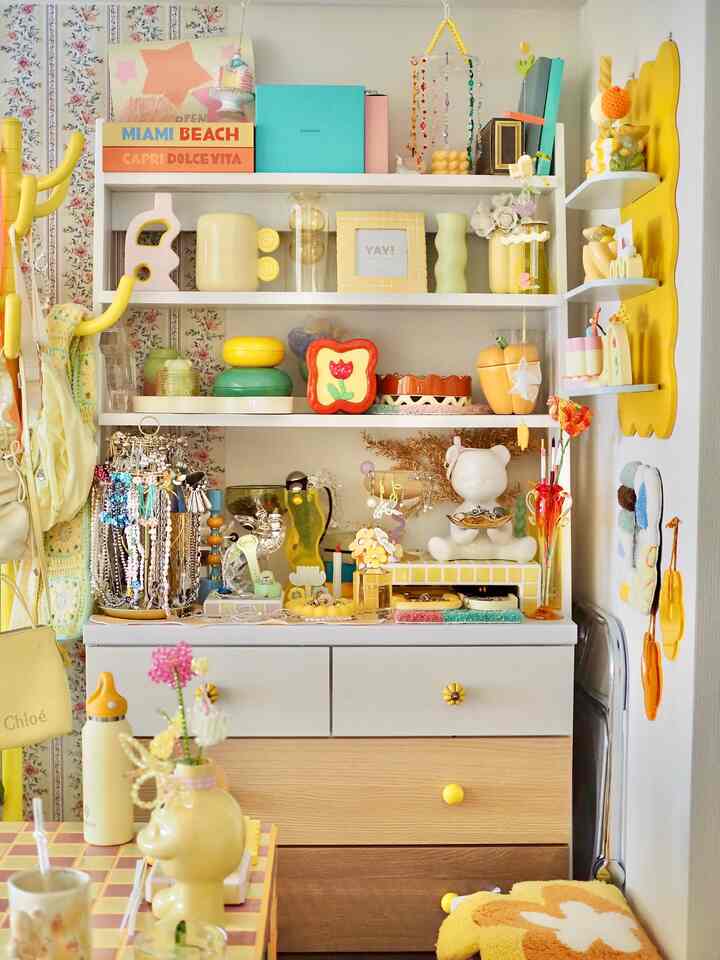 Bright yellow-themed dining room featuring shelves, storage furniture, and decorative items creating a cozy atmosphere
