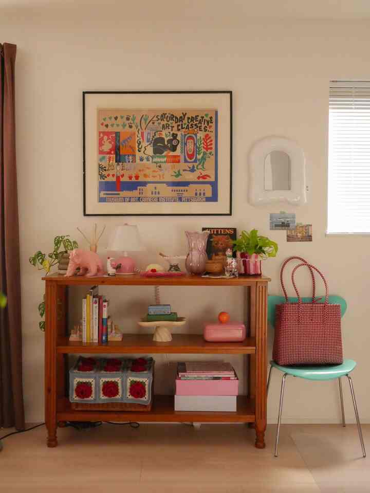 Warm wood tones with pink accents featuring a living room shelf and chair in a cozy retro atmosphere