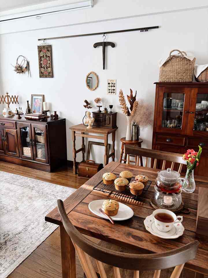 ナチュラルな木目調のダイニングルーム、ヴィンテージ家具とアンティーク装飾が配置された雰囲気のあるおうちカフェ