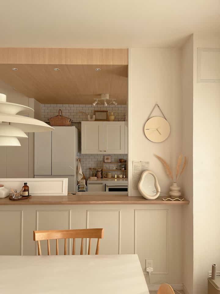 Beige and wood tone kitchen and dining room featuring a simple natural mood dining table and chair arrangement