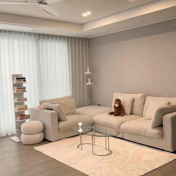 ベージュとウッドトーンのリビング、ベージュのソファとラグが配置され温かみのある落ち着いた空間