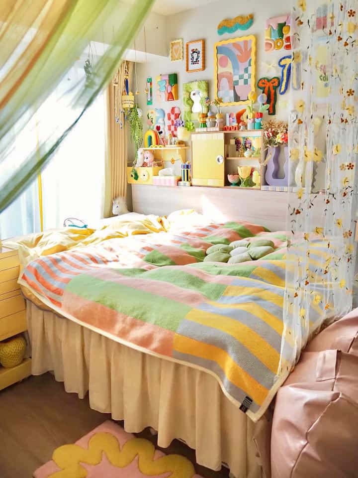 黄色の雰囲気の寝室、カラフルな寝具とベッドスカートが配置された明るいインテリア