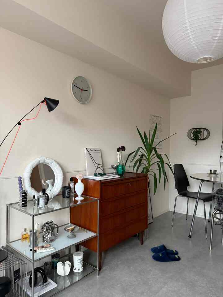 Mid-century modern Korean living room with white walls and brown wooden dresser