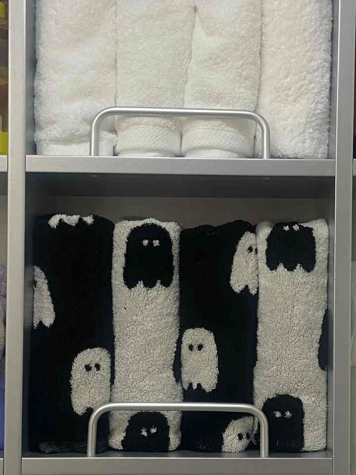 黒と白のゴースト柄タオルが整頓されたバスルームの棚