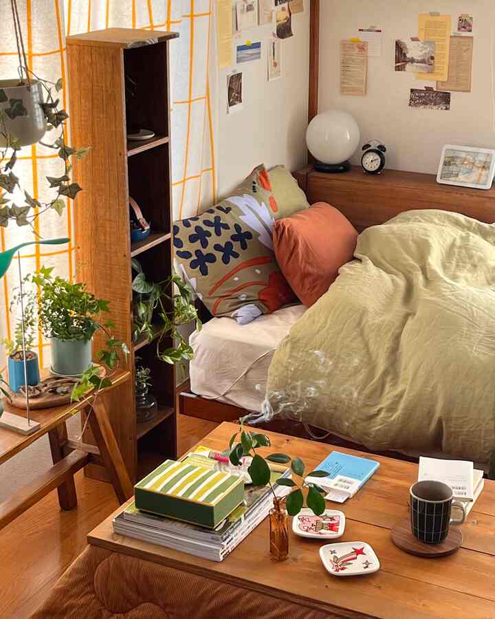 Natural bedroom with yellow curtains and brown wood tones, featuring stylish plants and cozy bedding in a single household space