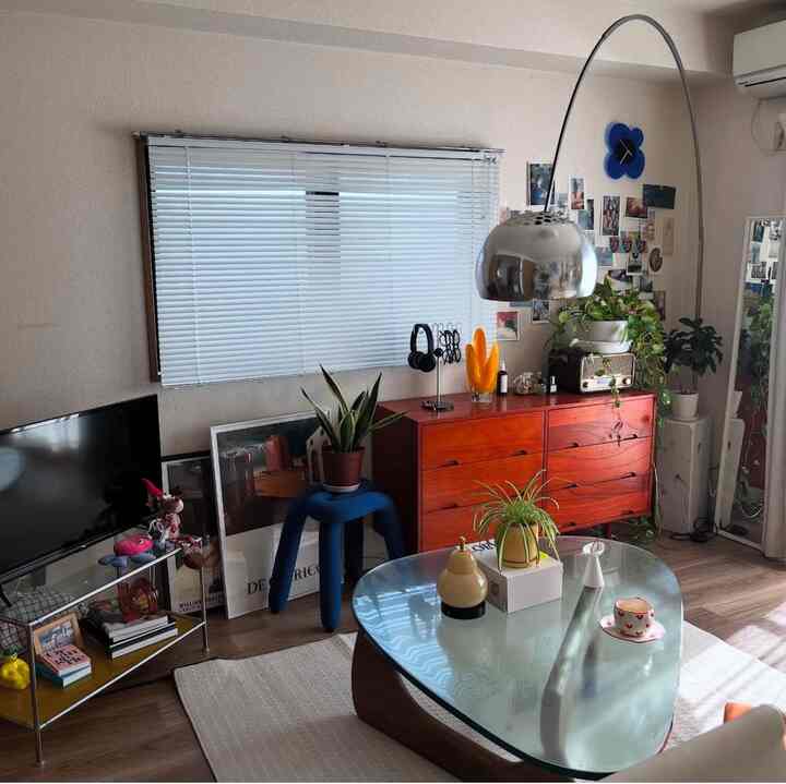 Beige-tone 8-tatami studio living room featuring an orange dresser, green plants, and mid-century modern lighting