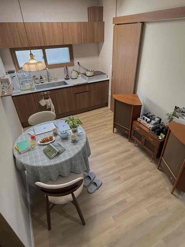 ナチュラルカラーの6畳ワンルームキッチンとダイニングスペース、自然な木材とシンプルなインテリアが印象的な空間