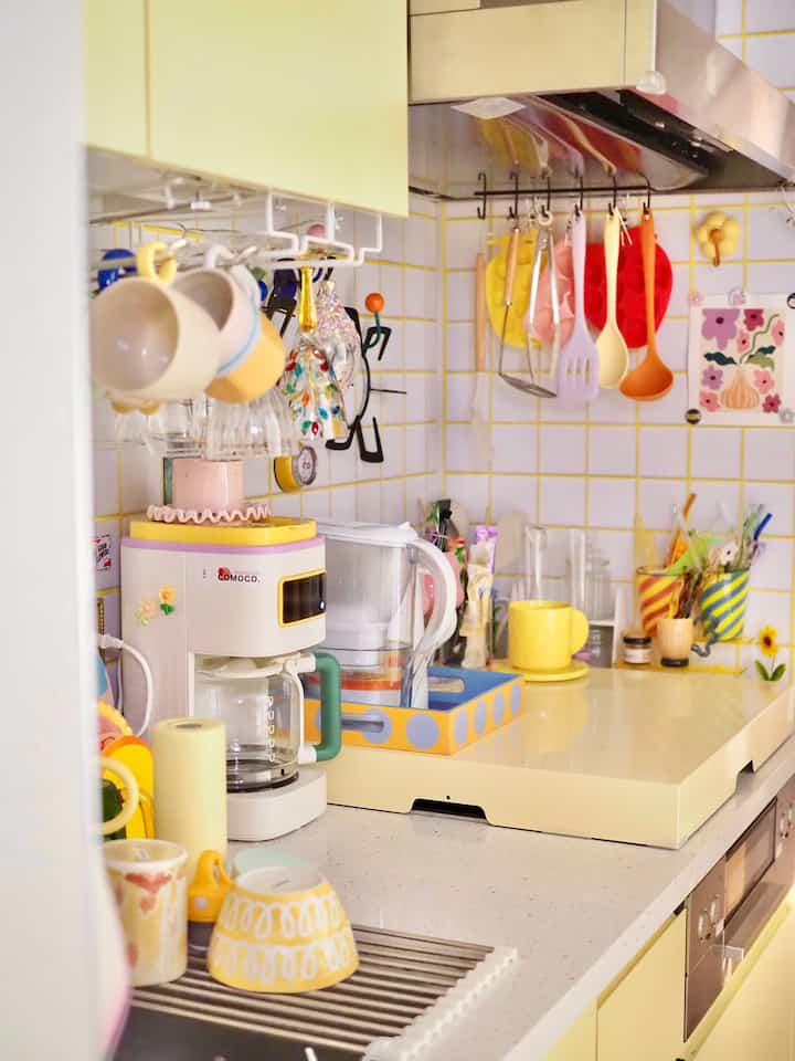 Bright yellow-toned kitchen featuring various cooking utensils and a coffee maker in a charming Korean interior setting