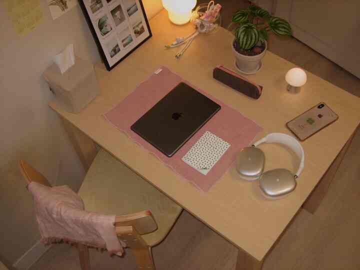 暖かい木目調のワンルーム空間、木製デスクと椅子、ノートパソコンと照明が配置された雰囲気のあるホームオフィス