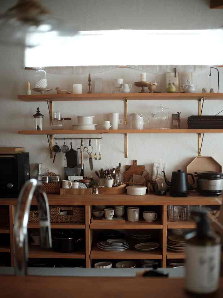 ナチュラルなブラウンとホワイトのトーンのキッチン空間、木製の棚とキッチン小物が配置された雰囲気のあるインテリア