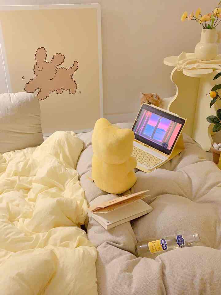 Beige and white toned living room featuring a large sofa bed, yellow plush toy, and iPad on a cozy setting