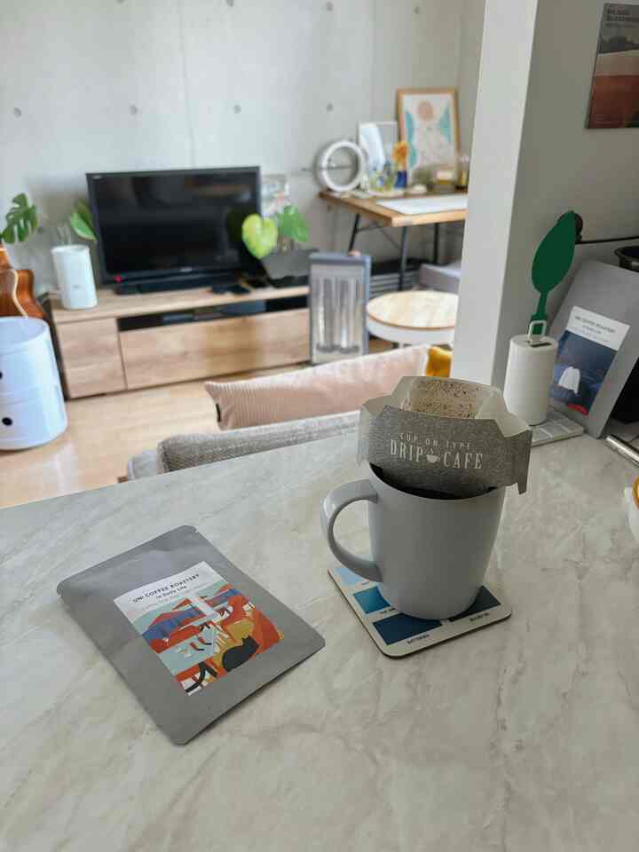 ナチュラルカラーのリビングとキッチンの空間、コーヒードリップセットが置かれた清潔感のあるおうちカフェのインテリア