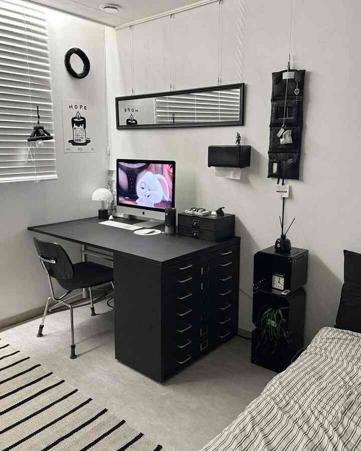 モノトーンのブラックインテリアのホームオフィス、黒いデスクとチェスト、椅子が配置された整然とした空間