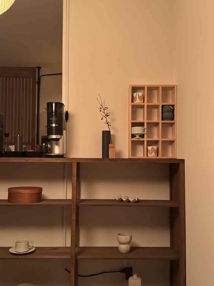温かみのあるナチュラルな木目調のキッチン棚に、美しく並べられた食器とコーヒー器具があるおうちカフェの雰囲気