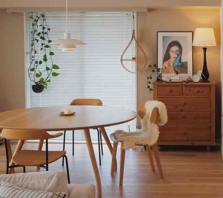 ブラウンの木目調のダイニングルーム、木製のダイニングテーブルと椅子、ヴィンテージのチェストが配置された温かみのある空間