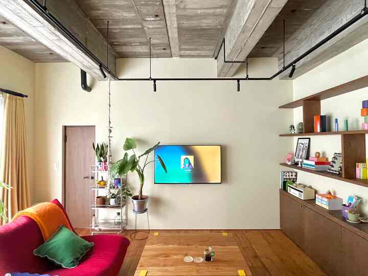 Beige-toned living room featuring a red sofa and wood shelves with a natural atmosphere