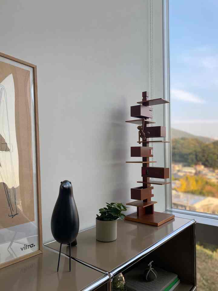 Beige and white toned living room featuring a sideboard with Vitra objets and a small plant, in a sleek modern interior