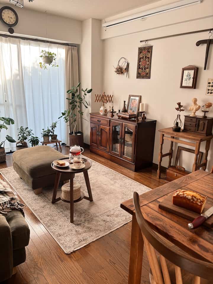 Warm wood-toned dining room featuring vintage furniture and plants, creating a cozy home cafe atmosphere