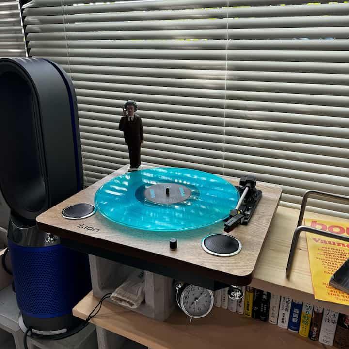 透明なレコードプレーヤーとブラインドがあるコンパクトな部屋の雰囲気あるインテリア