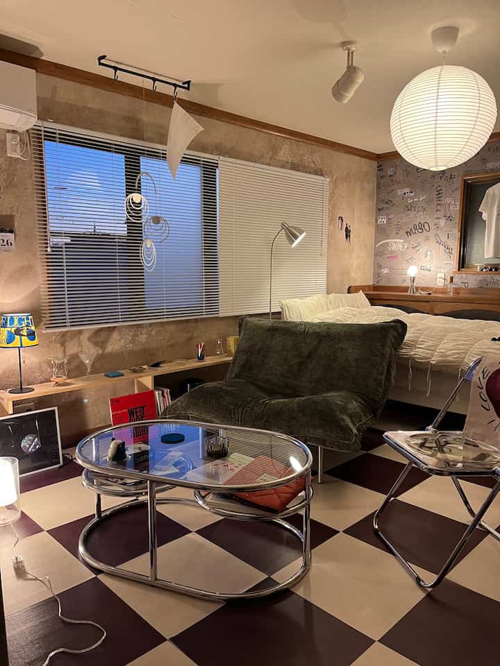 Brown toned wall and white lighting blend in a Mid-Century Modern living and bedroom hybrid space