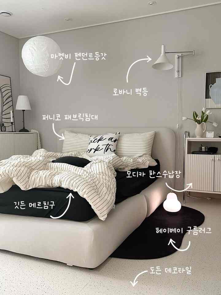 Modern beige-toned bedroom featuring a large fabric bed, black cloud-shaped rug, and wall sconces adding cozy accents