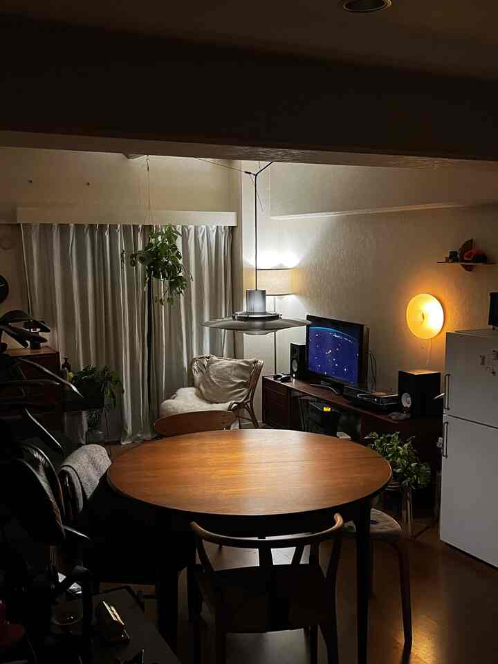 ブラウンとホワイトのトーンが特徴的なダイニングルーム、円形のダイニングテーブルとペンダントライトが落ち着いた雰囲気のインテリア