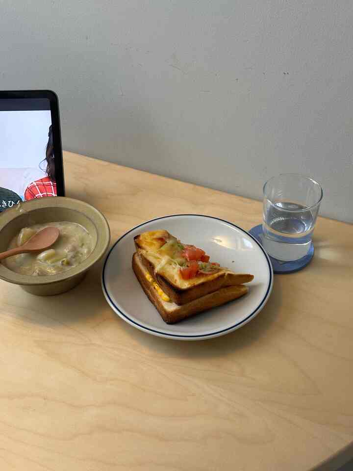 Cozy 1K home cafe space featuring a light wood dining table with white plates and bowl
