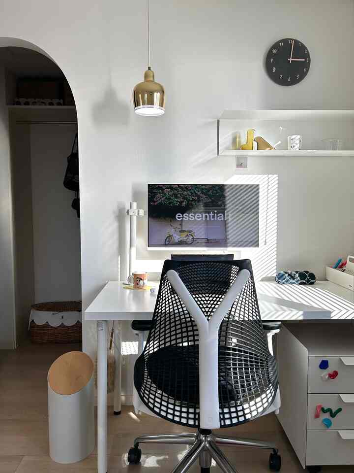 Modern bedroom workspace in white and gold tones featuring a desk and office chair neatly arranged