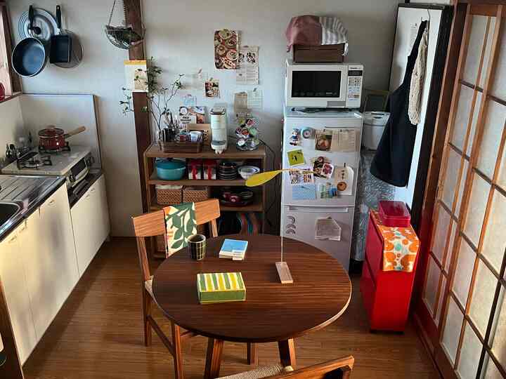 Natural wood tone single household kitchen and dining area featuring cozy home cafe elements and compact furniture