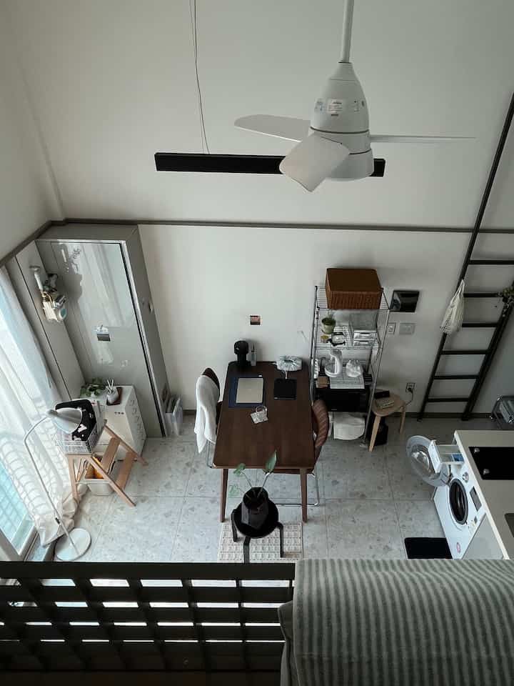 白い壁と木目調家具が配置されたロフトのワンルームダイニング、居心地の良いヴィンテージ風インテリア