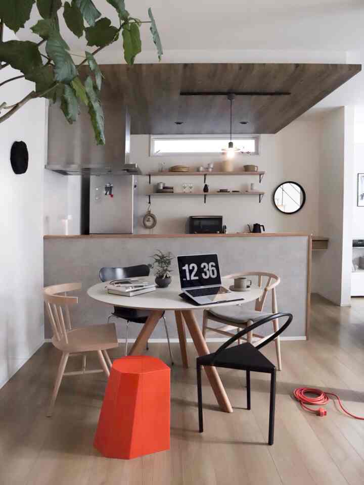 White and brown toned dining room featuring various chairs and an orange stool, creating a natural and warm atmosphere