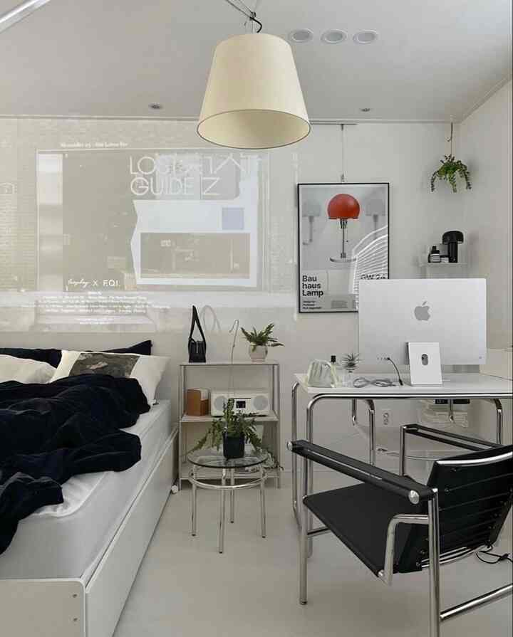 白を基調とした寝室、ミッドセンチュリーモダンチェアとデスクが配置されたシンプルな空間