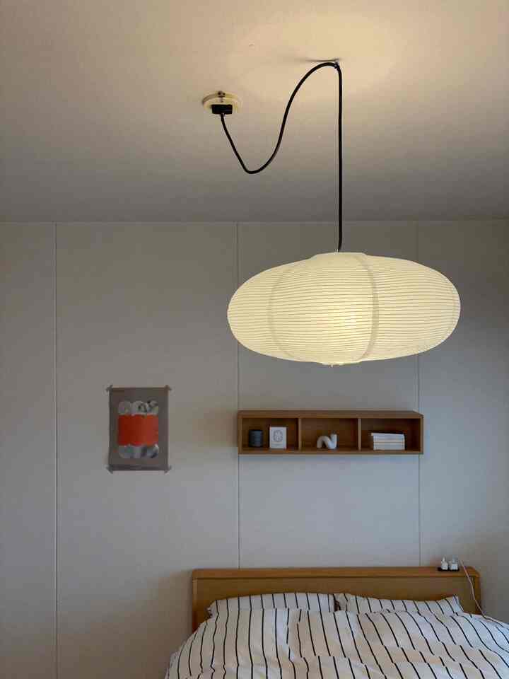 明るい木目調と白い壁の二人暮らし用寝室、ペンダントライトが柔らかい自然な雰囲気を演出するインテリア