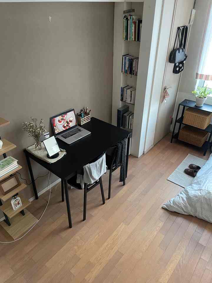 ウッドトーンとブラックが調和する8坪のワンルーム寝室とホームオフィスの雰囲気ある空間