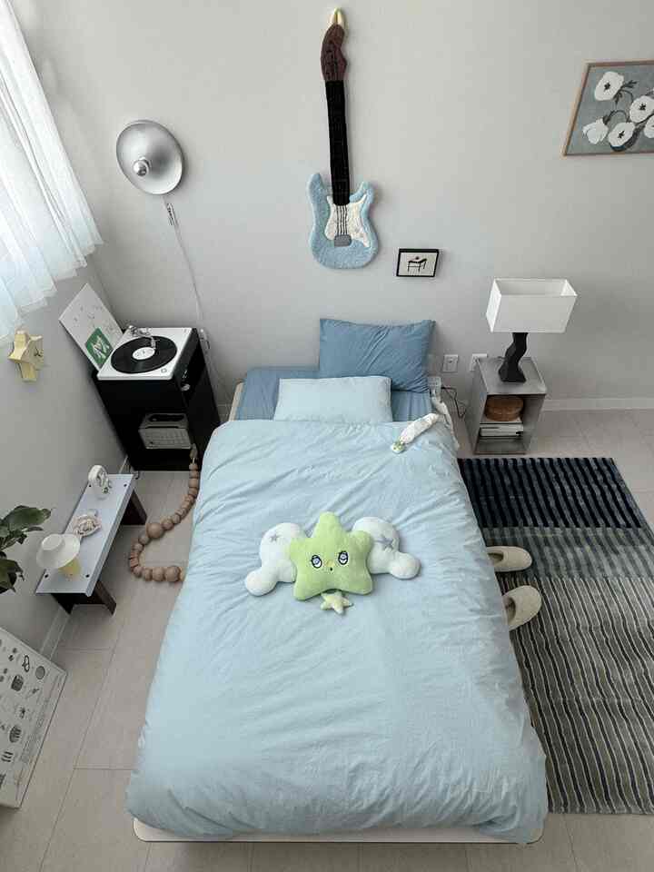 白と青のトーンが特徴の6畳寝室、シングルベッドとミニマルで落ち着いた雰囲気のインテリア