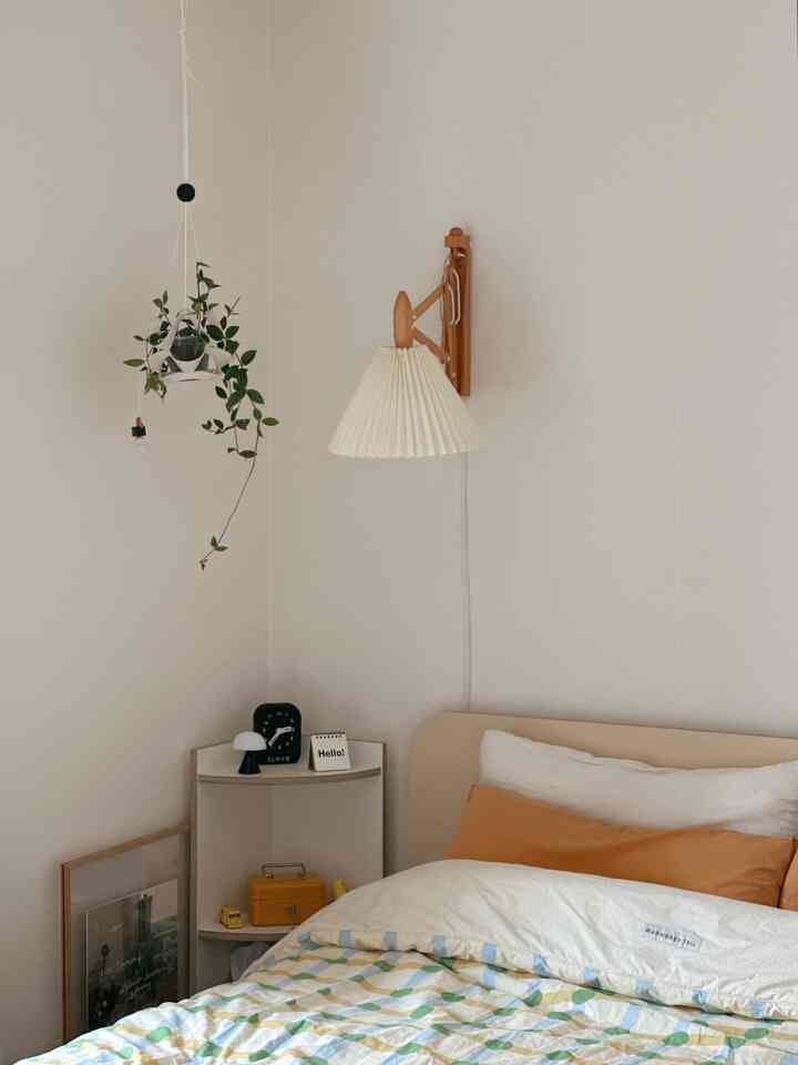 明るいホワイトとベージュの6畳寝室、自然素材とハンギングプランツが調和した落ち着いた空間