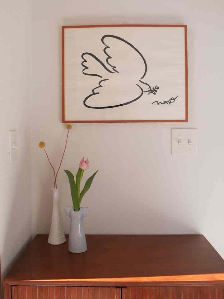 白を基調とした玄関、木目調のコンソールに花瓶と鳥の絵が配置された雰囲気のあるインテリア