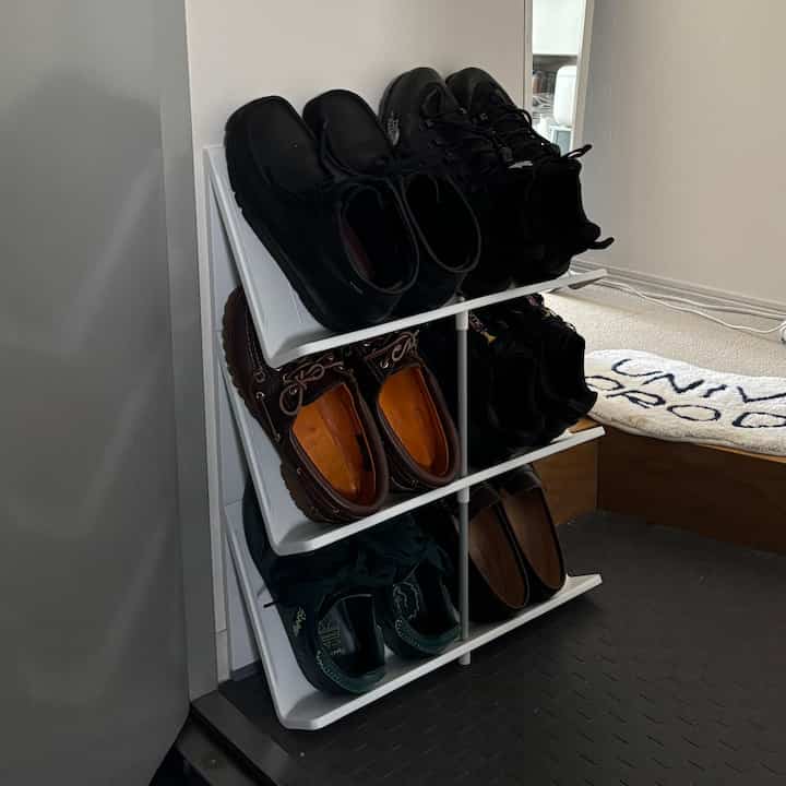 白を基調とした玄関、壁際に配置されたスリムな3段シューズラックがすっきりとした空間効率の良いインテリアを演出