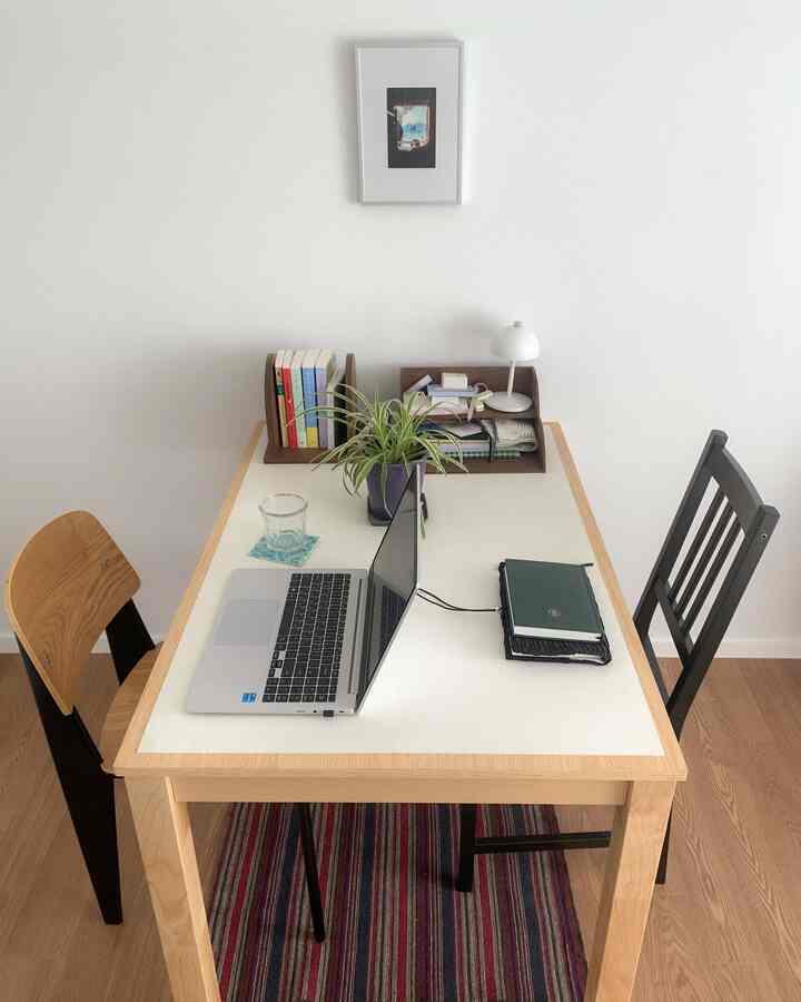 ナチュラルな色調のシンプルモダンな二人暮らし用ホームオフィス、白いテーブルと木製椅子が配置された印象的な空間