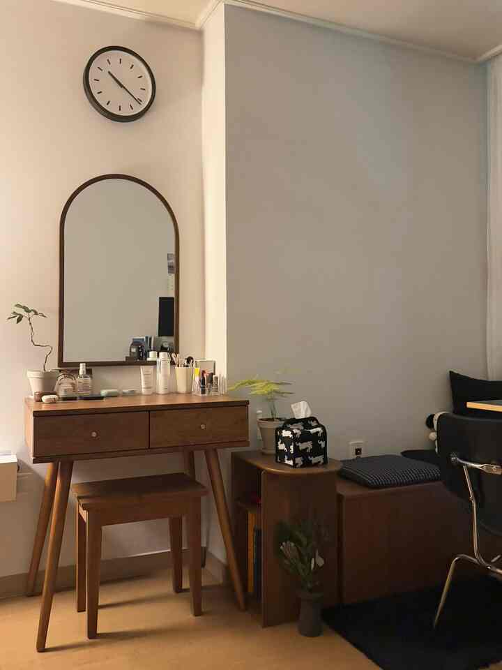 木目調とブラックを基調とした寝室、化粧台と鏡、実用的な収納が配置されたモダンな雰囲気のインテリア