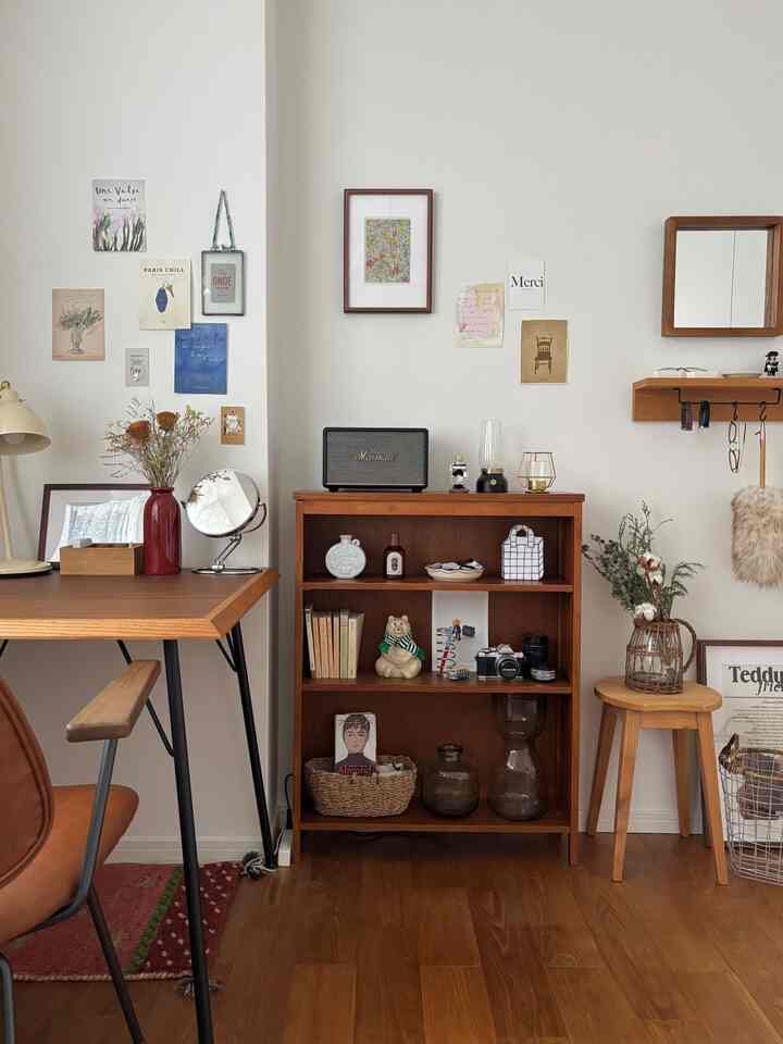 Brown wood-toned and white-walled single household hobby space featuring a desk, bookshelf, and stool with a natural atmosphere