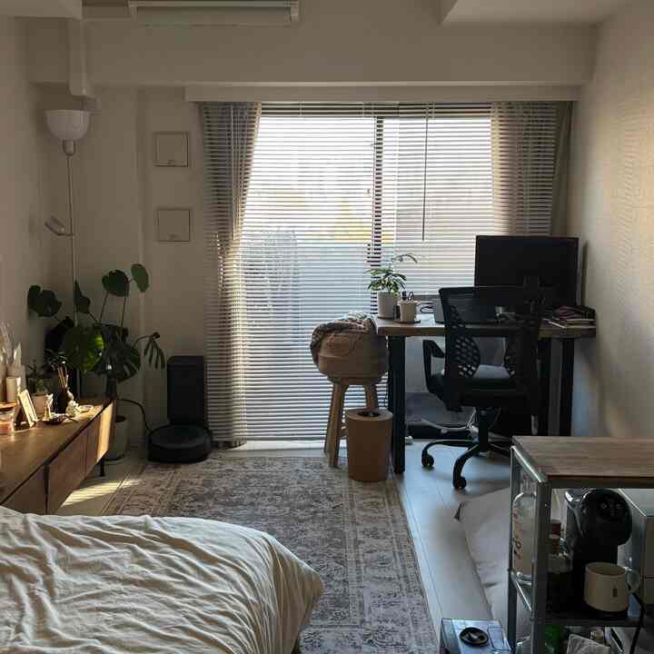 Wood tone-based 8-tatami studio apartment home office with desk and office chair arranged in a cozy single household room