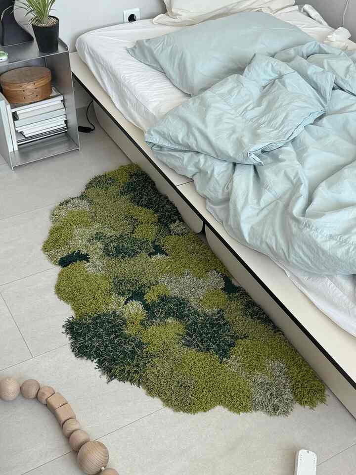 パステルブルーの寝具と淡いグリーンのテクスチャードラグが配置されたナチュラルな雰囲気の寝室