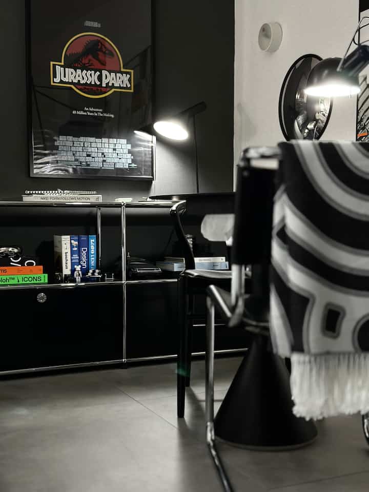 黒と白のトーンのホームオフィス、デスクとオフィスチェア、照明が配置されたモダンな書斎のインテリア