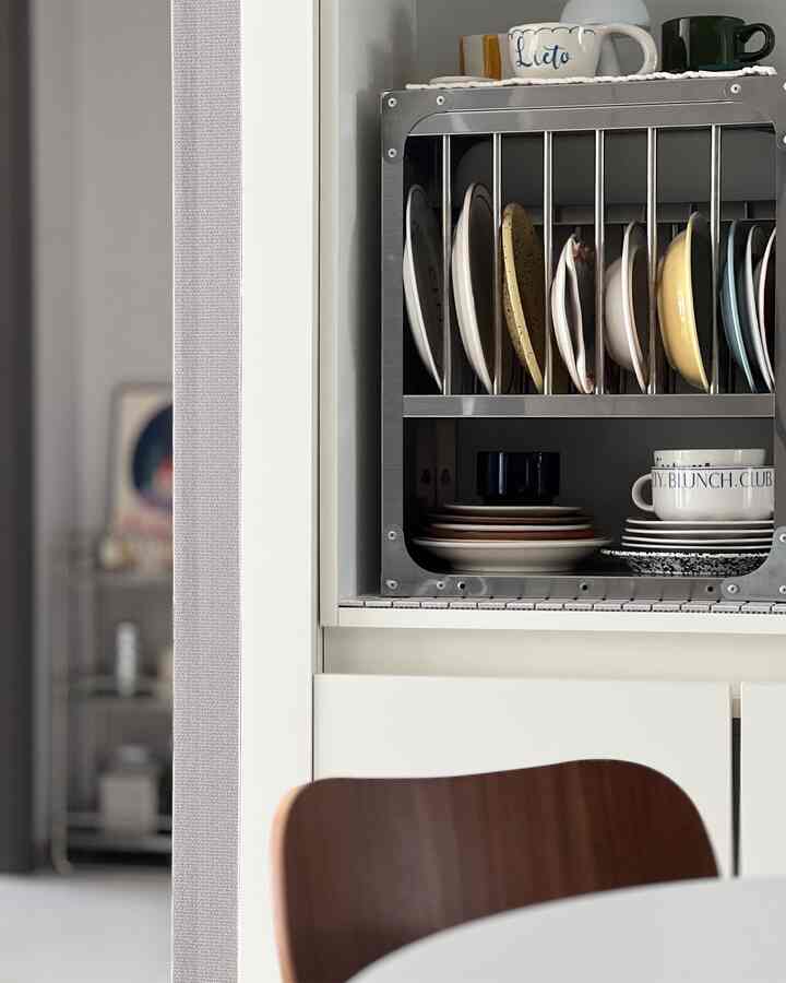 ホワイトとブラウンのトーンのキッチン空間、きれいに整理されたキッチンラックと食器が配置されたミニマルな雰囲気のインテリア