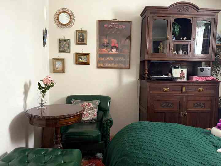 Vintage retro living room corner featuring green leather armchair and antique wooden furniture with cozy atmosphere