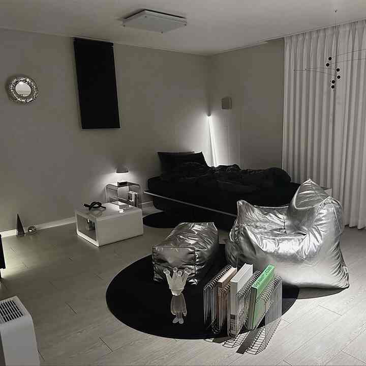 モノトーンの一人暮らし寝室、黒いベッドと銀色のビーズクッションが配置されたモダンで清潔感のある空間
