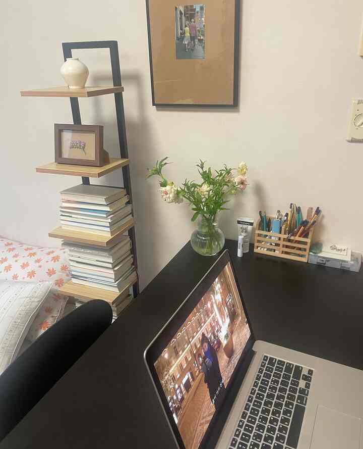 黒いデスクとノートパソコンが配置されたシンプルモダンな寝室の書斎スペース